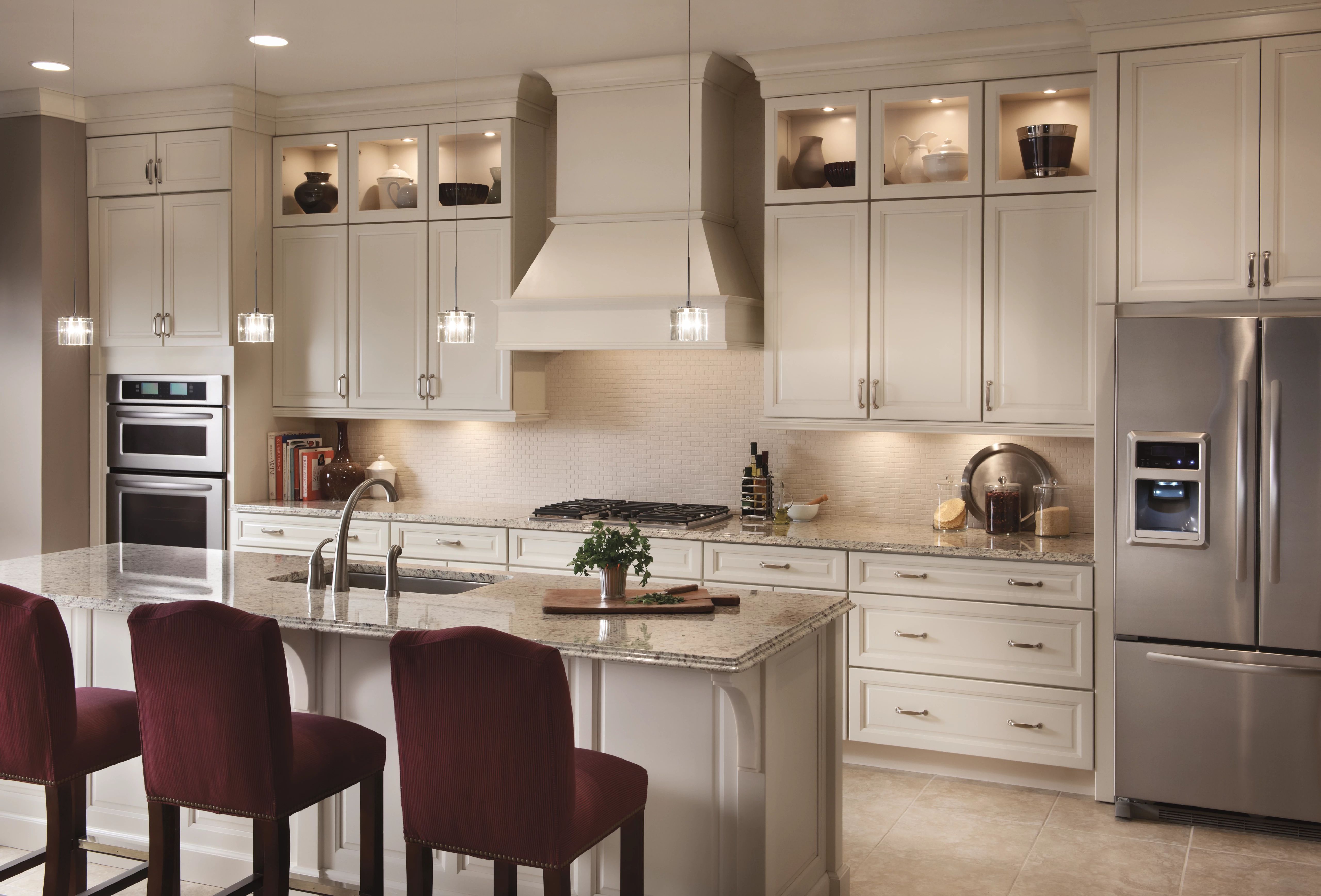 Granite countertops and white cabinets create a stunning neutral-color KraftMaid kitchen